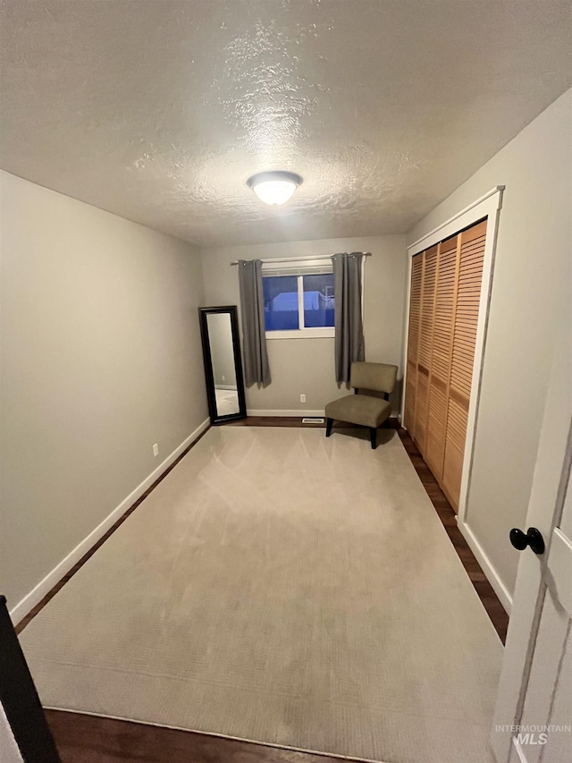 unfurnished bedroom with a closet, carpet floors, and a textured ceiling