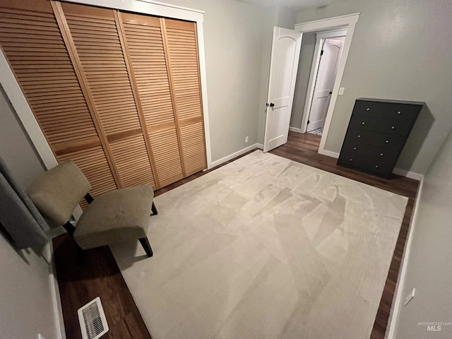 unfurnished bedroom featuring a closet and dark wood-type flooring