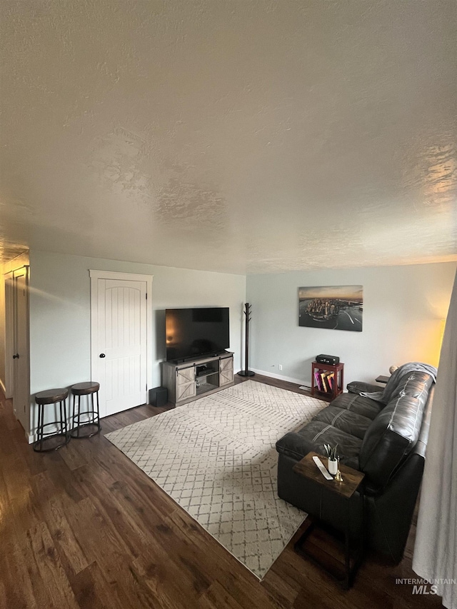 living room featuring dark hardwood / wood-style flooring and a textured ceiling