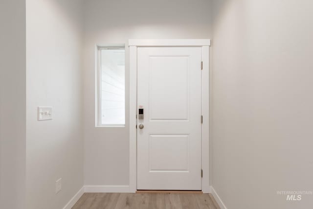 doorway to outside featuring light wood finished floors and baseboards