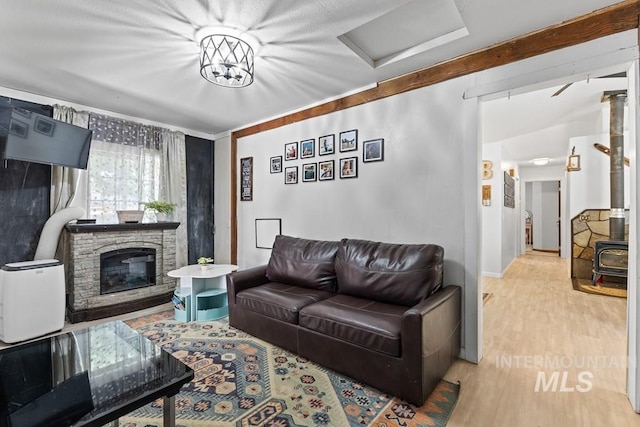 living room featuring light hardwood / wood-style floors and a stone fireplace