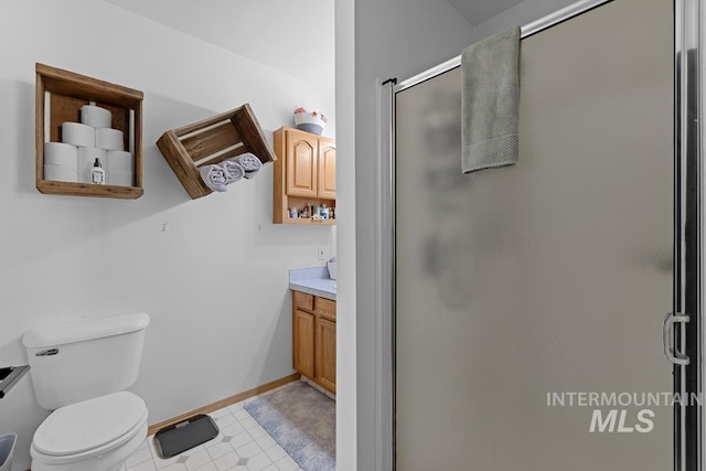 bathroom with vanity, toilet, a shower with door, and tile patterned floors