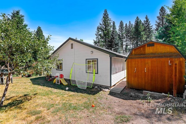 exterior space featuring a lawn and a storage shed