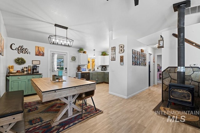 dining space featuring a wood stove and light hardwood / wood-style floors