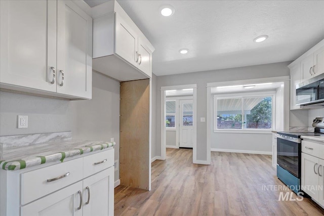 414 Yakima Ave, Filer, ID 83328 - kitchen with appliances with stainless steel finishes, light wood-style flooring, white cabinets, recessed lighting, and light stone counters