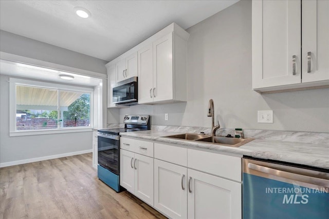 414 Yakima Ave, Filer, ID 83328 - kitchen with stainless steel appliances, light wood finished floors, light countertops, and white cabinets