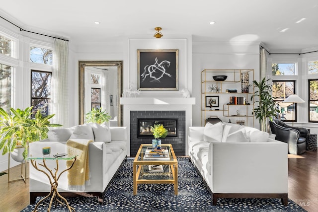 living room featuring a fireplace, a wealth of natural light, and crown molding