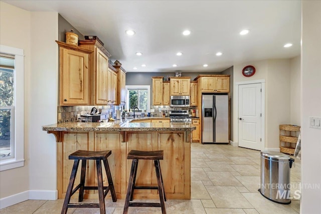 45 Ridge Loop, Jerome, ID 83338 - kitchen with appliances with stainless steel finishes, a peninsula, tasteful backsplash, recessed lighting, and a kitchen bar