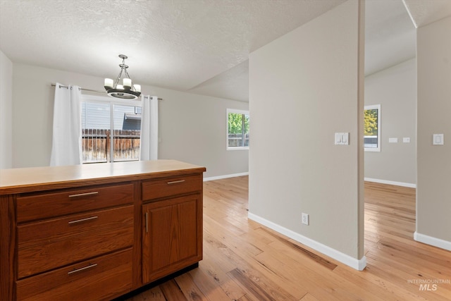 1406 W Wright St, Boise, ID 83705 - kitchen featuring baseboards, light wood finished floors, a chandelier, light countertops, and a textured ceiling
