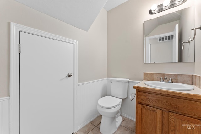 1406 W Wright St, Boise, ID 83705 - half bath featuring vanity, a wainscoted wall, toilet, tile patterned flooring, and vaulted ceiling
