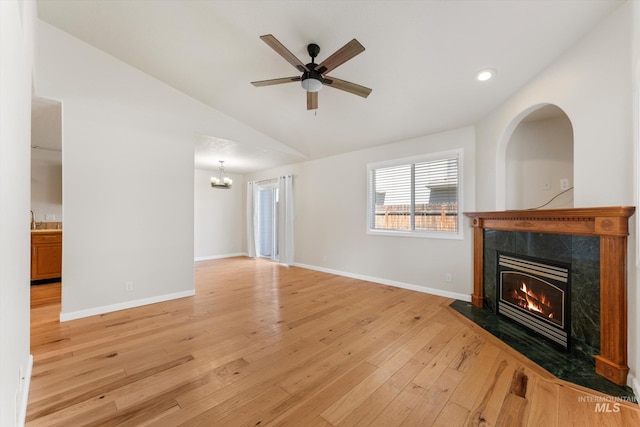 1406 W Wright St, Boise, ID 83705 - unfurnished living room with a high end fireplace, light wood-style floors, vaulted ceiling, baseboards, and a chandelier