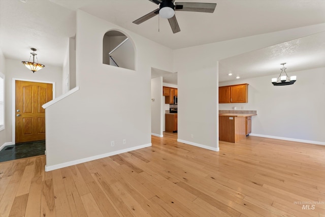 1406 W Wright St, Boise, ID 83705 - unfurnished living room with a chandelier, light wood-style floors, and ceiling fan