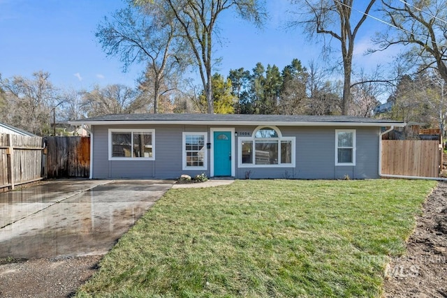 ranch-style home with a front lawn and fence