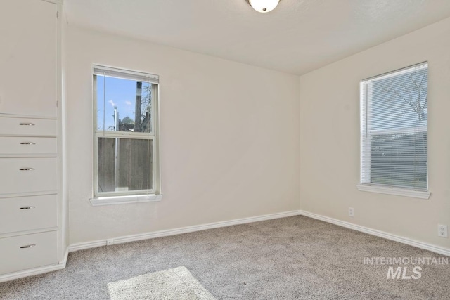 empty room with carpet floors and baseboards