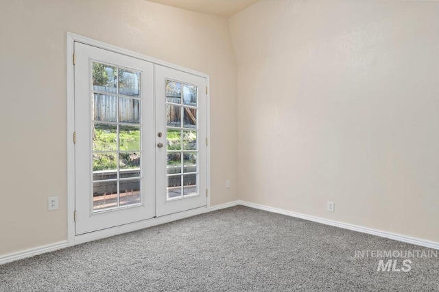 carpeted spare room featuring baseboards and french doors