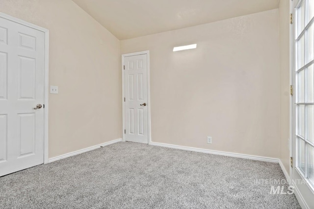 carpeted empty room featuring baseboards