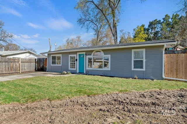 ranch-style home with fence and a front lawn