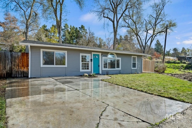 single story home with fence and a front lawn