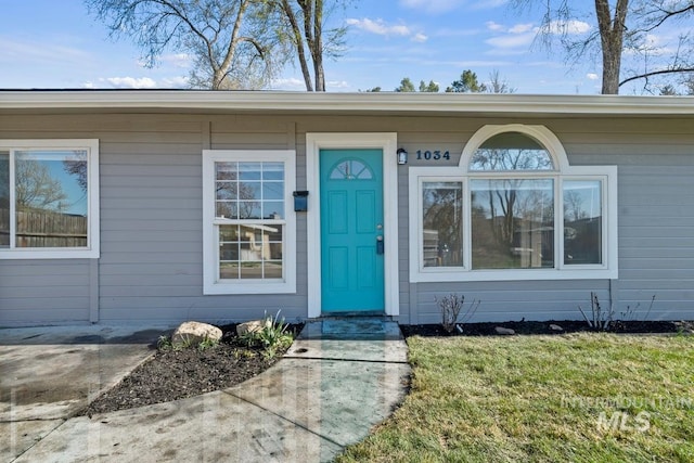view of exterior entry featuring a yard