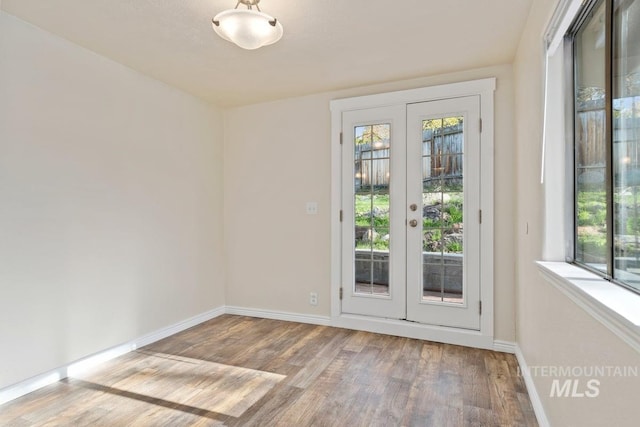 doorway to outside featuring french doors, baseboards, and wood finished floors