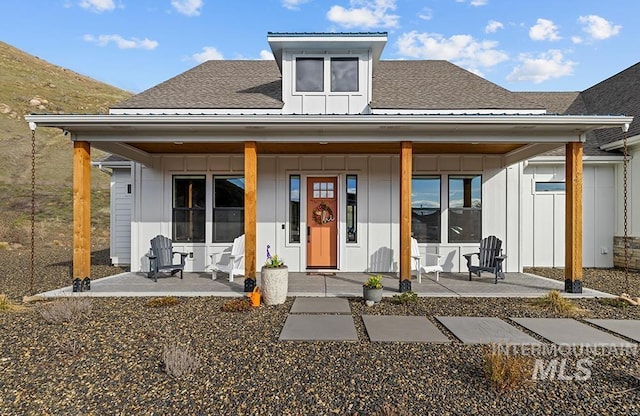 view of front facade with a porch, board and batten siding, and a shingled roof