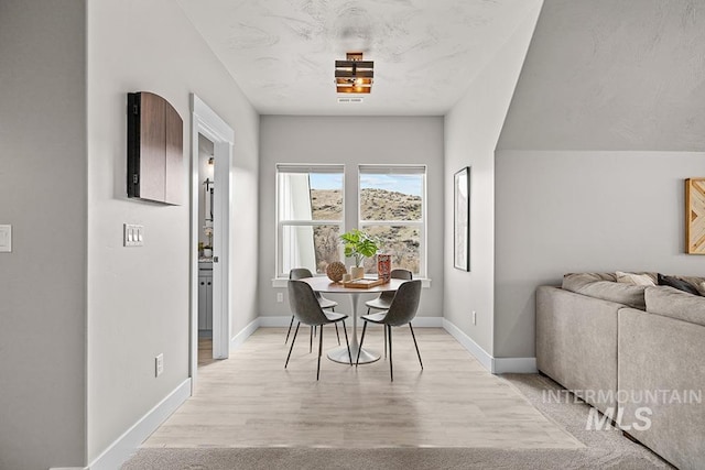 dining area featuring baseboards and light wood-style floors