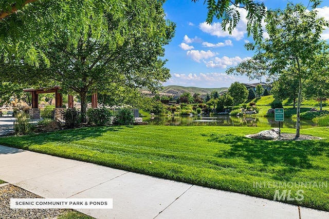 surrounding community featuring a lawn and a water and mountain view