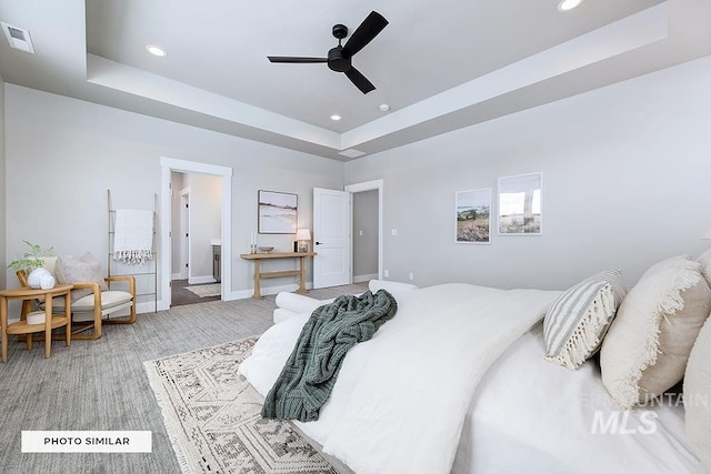 bedroom with a tray ceiling, a ceiling fan, visible vents, recessed lighting, and light carpet