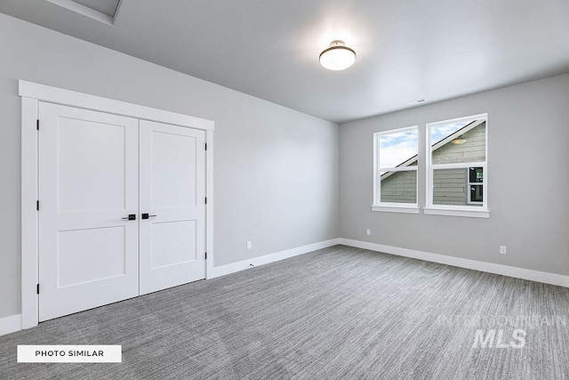 unfurnished bedroom featuring a closet, baseboards, and carpet