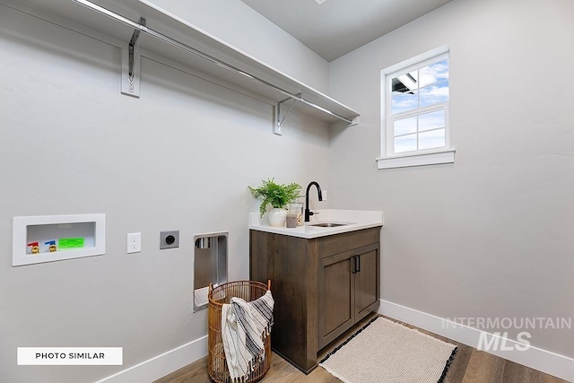 washroom with a sink, baseboards, electric dryer hookup, and hookup for a washing machine