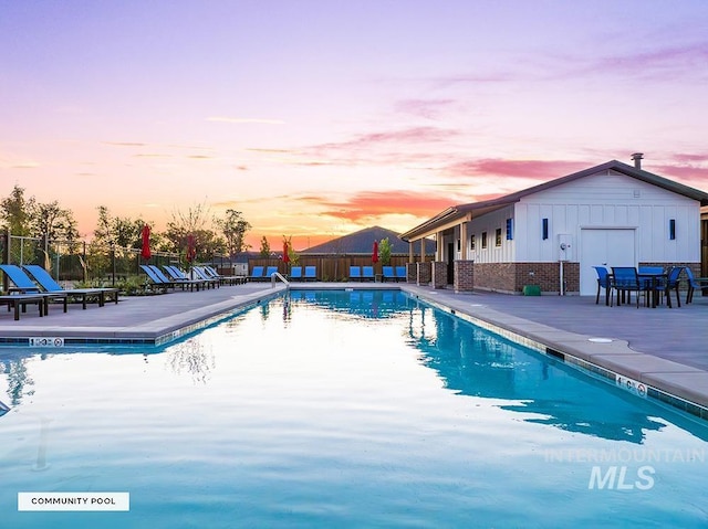 pool with a patio area and fence