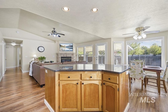 2189 W Rainfall St, Meridian, ID 83646 - kitchen featuring a ceiling fan, light wood-style floors, a textured ceiling, healthy amount of natural light, and vaulted ceiling