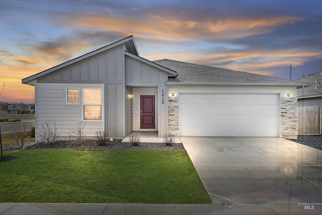 view of front of house with board and batten siding, an attached garage, a front lawn, fence, and driveway