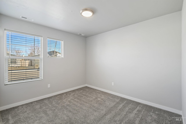 spare room with visible vents, baseboards, and carpet