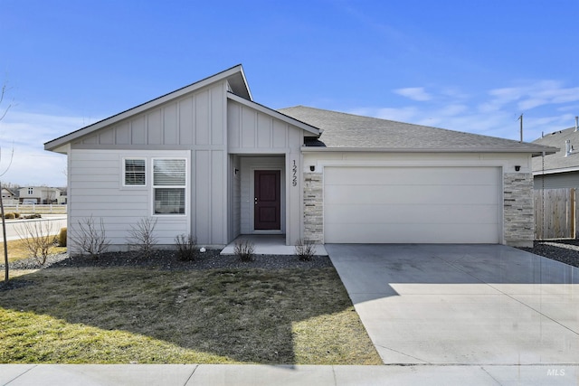 view of front of property featuring fence, concrete driveway, a garage, stone siding, and board and batten siding