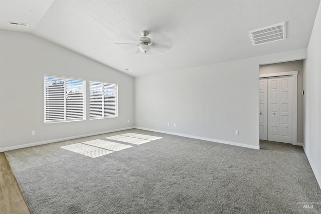 spare room with visible vents, lofted ceiling, ceiling fan, and carpet flooring