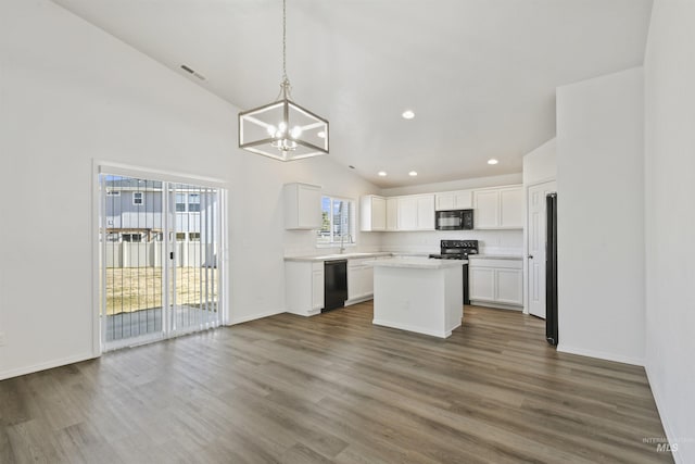 kitchen with dark wood-style floors, plenty of natural light, black appliances, and an inviting chandelier