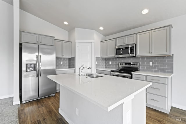 kitchen with a sink, appliances with stainless steel finishes, gray cabinetry, and light countertops