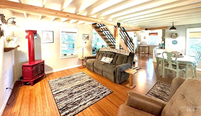 3617 Rubicon St, New Meadows, ID 83612 - living room with wood finished floors, a wood stove, beam ceiling, baseboards, and stairway