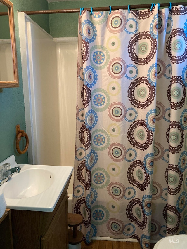 bathroom featuring a shower with curtain, vanity, hardwood / wood-style floors, and toilet