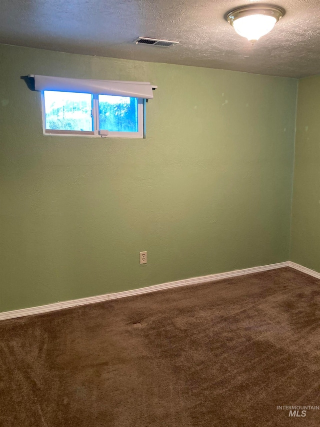 carpeted empty room with a textured ceiling