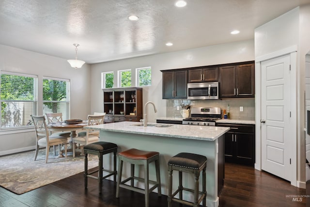 12022 W Ardyce, Boise, ID 83713 - kitchen featuring stainless steel appliances, dark wood-style flooring, a kitchen breakfast bar, backsplash, and dark brown cabinetry