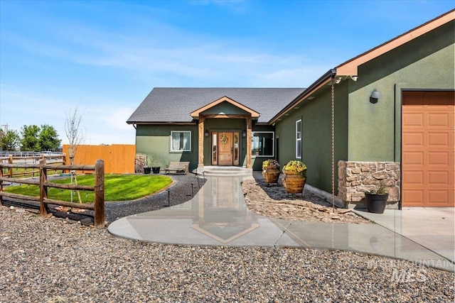 1770 N 3rd St, Nyssa, OR 97913 - view of front of home with stucco siding, stone siding, and an attached garage