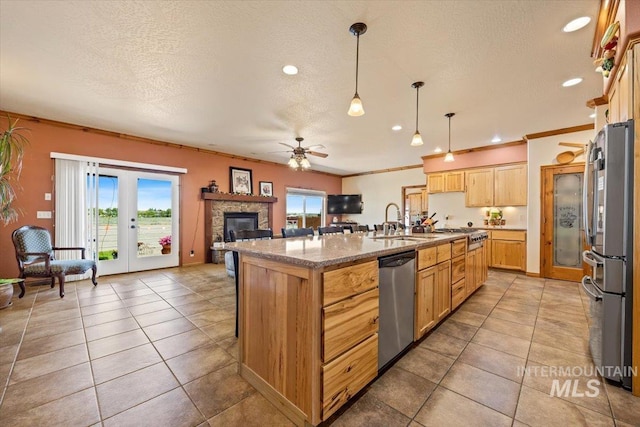 1770 N 3rd St, Nyssa, OR 97913 - kitchen featuring appliances with stainless steel finishes, a sink, a ceiling fan, an island with sink, and a textured ceiling