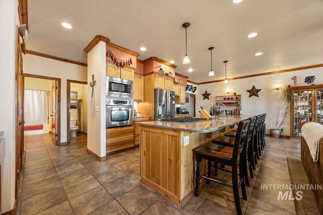 1770 N 3rd St, Nyssa, OR 97913 - kitchen with appliances with stainless steel finishes, a spacious island, dark stone counters, crown molding, and a breakfast bar area