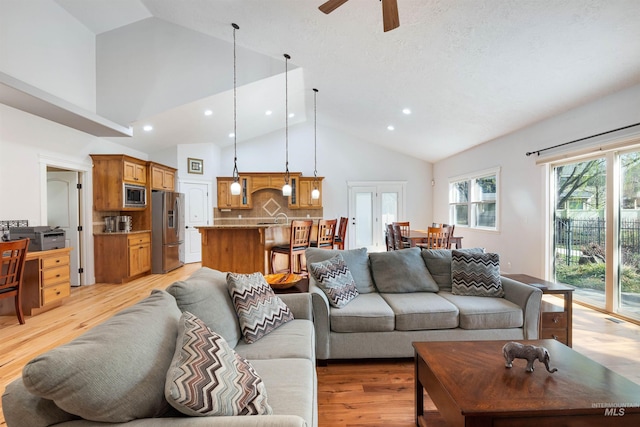 living area with light wood-type flooring, high vaulted ceiling, a ceiling fan, and recessed lighting