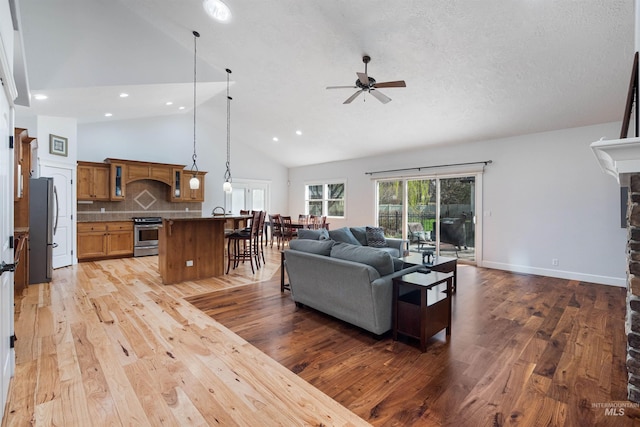 living room featuring baseboards, recessed lighting, ceiling fan, high vaulted ceiling, and light wood finished floors