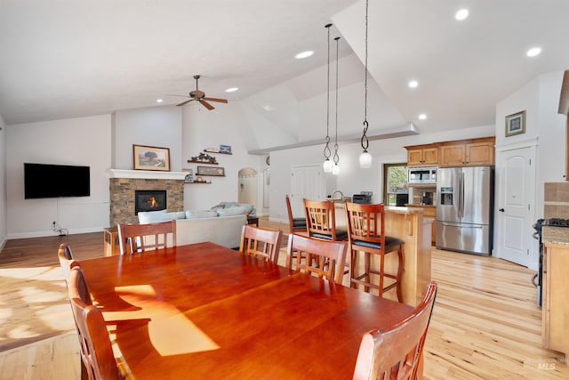 dining space featuring light wood-style floors, ceiling fan, a fireplace, and recessed lighting