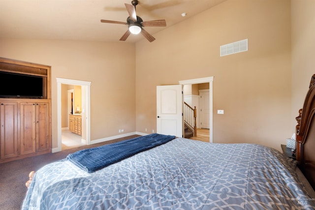carpeted bedroom with ceiling fan, high vaulted ceiling, ensuite bath, visible vents, and baseboards