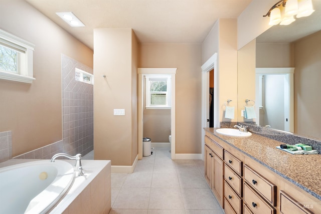 bathroom with vanity, baseboards, tile patterned floors, toilet, and a bath